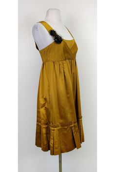 With its gorgeous gold tone color and feminine empire waist silhouette, this dress is a polished choice. Perfect for any party, style it with gold-tone jewelry and chic pumps. Size 6 60% silk, 40% rayon Back zipper closure Beaded detail on strap Empire waist silhouette Ruffles along hem Lined Bust 31" Waist 28.5" Shoulder to hem 38.25" Gold A-line Silk Dress, Gold A-line Evening Dress, Elegant Gold A-line Dress, Glamorous Gold A-line Dress, Gold Cocktail Dress With Fitted Bodice, Gold Satin Dress With Fitted Bodice, Chic Gold Formal Dress, Gold Silk Cocktail Dress, Spring Cocktail Dress In Gold