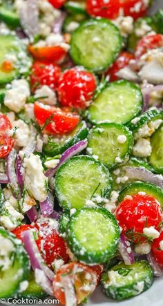 cucumber, tomato and onion salad with feta cheese in a white bowl