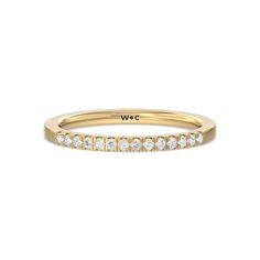 a yellow gold band with white diamonds on the side and we written in cursive writing