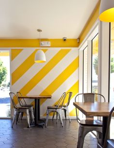 an empty restaurant with yellow and white striped walls