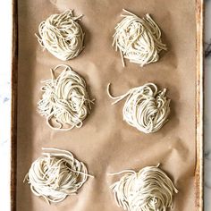 six uncooked pasta balls on a baking sheet ready to go into the oven