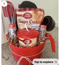 a red bucket filled with cookies and other items on top of a carpeted floor