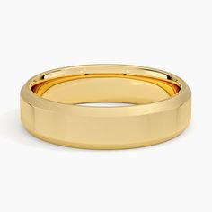 a yellow gold wedding ring on a white background