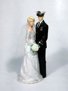 a bride and groom figurine are posed on a white background for a wedding photo