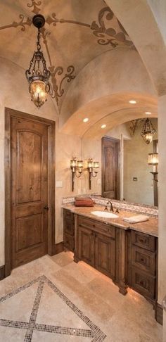 a large bathroom with double sinks and an ornate ceiling light hanging from the ceiling above it