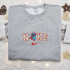 The Nike Christmas x Stitch Hey Embroidered Sweatshirt is the perfect festive addition to your wardrobe. Made with high-quality materials, Cute Nike Hoodies, Nike Cartoon, Disney Character Shirts, Good Christmas Gifts, Nike Hoodies, Nike Inspired, Things For Christmas, Secret Santa Ideas, Nike Clothes