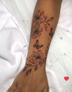 a woman's arm with flowers and butterflies on it