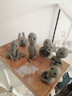 several clay animals sitting on top of a wooden table