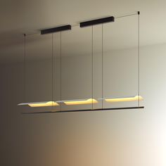 three rectangular lights hanging from the ceiling in a dimly lit room with white walls and flooring