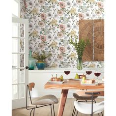 the dining room is decorated with floral wallpaper and wooden table, along with two chairs