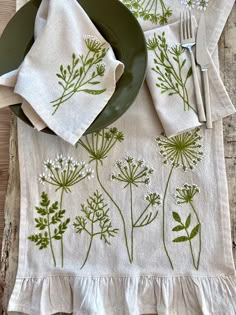 a place setting with green and white flowers