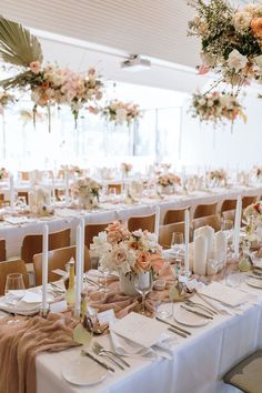 the tables are set with white linens and floral centerpieces for an elegant wedding reception