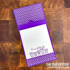 a purple and white card with the words i love you on it, sitting on top of a wooden table