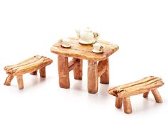 a small wooden table with two benches and a tea pot on it, set against a white background