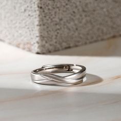 two silver rings sitting on top of a table