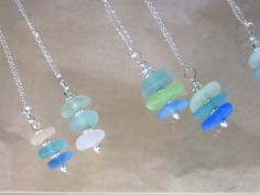 four different colored glass beads hanging from silver chains