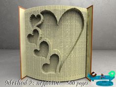 an open book with two hearts cut out of it and the pages are folded in half