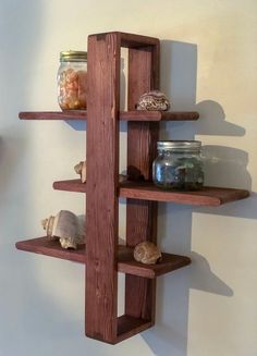 three wooden shelves with jars and seashells on them