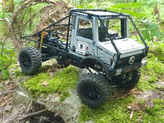 a toy truck is sitting on top of a rock in the middle of the woods