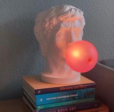 there is a light that looks like a head on top of some books