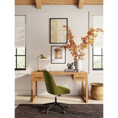 a green chair sitting in front of a desk with pictures on the wall behind it