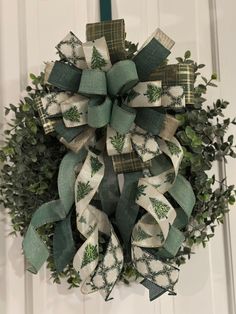 a green and white christmas wreath hanging on a door