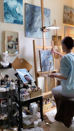 a woman is painting in an art studio