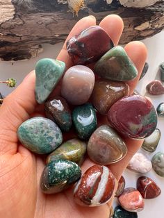 a hand holding several different colored rocks