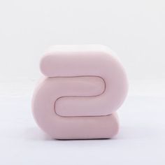 the letter s is made out of pink plastic and sits on top of a white surface