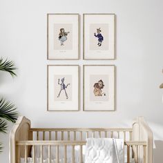 three framed pictures hang on the wall above a crib