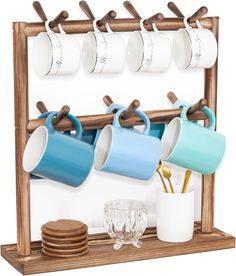 a wooden rack with cups and plates on it next to a cup holder that holds four mugs