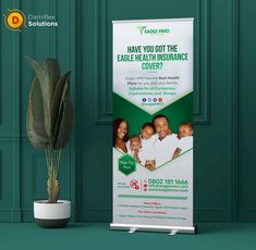 a roll - up banner stands next to a potted plant on a green wall