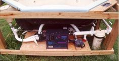 the back end of a wooden structure with various pipes and equipment in it, including a water heater