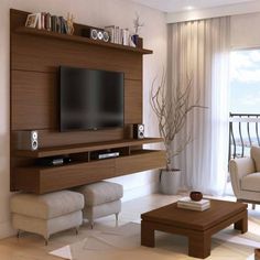 a living room with a large tv mounted on the wall and speakers in front of it