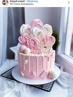 a pink cake with white icing and flowers on top