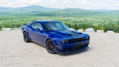 a blue sports car parked on top of a hill