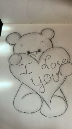 a drawing of a teddy bear holding a heart with the words i love you written on it