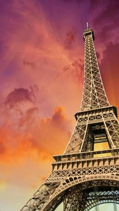 the eiffel tower in paris, france is lit up at sunset with pink clouds