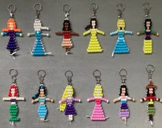 many different colored beaded key chains are arranged in the shape of women with arms and legs