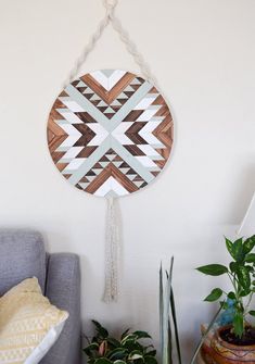 a wall hanging made out of wood and rope with a geometric design on the side