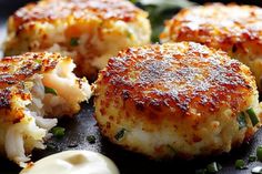 some crab cakes are on a black plate