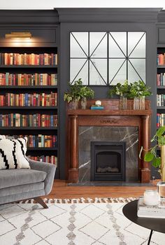 a living room filled with furniture and a fire place in front of a bookshelf