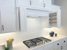 a stove top oven sitting inside of a kitchen next to white cabinets and cupboards