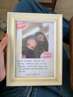 two women sitting next to each other in front of a white frame with the words i love you on it