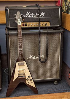 an electric guitar sitting on top of a table next to a speaker and amps