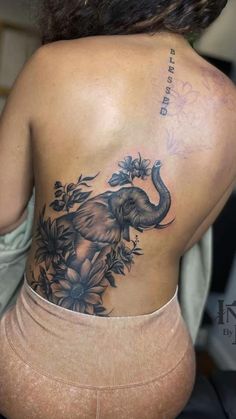 an elephant tattoo on the back of a woman