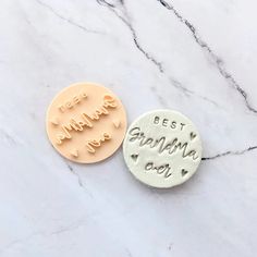 two personalized buttons with the words best grandma ever on them sitting on a marble surface