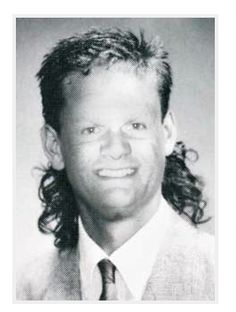 a black and white photo of a man with long hair wearing a suit and tie