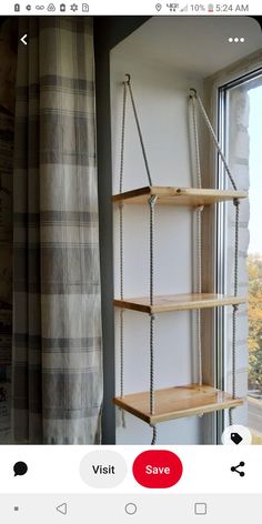 an empty shelf next to a window in a room with a plaid curtain on it