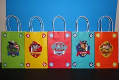 the paw patrol paper bags are lined up in a row on a black table against a blue wall